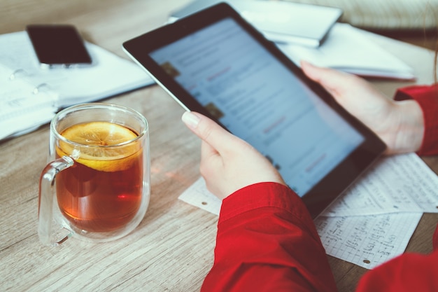A student completing the FAFSA form on a tablet in a coffee shop, highlighting the accessibility and flexibility of online education and financial aid applications.