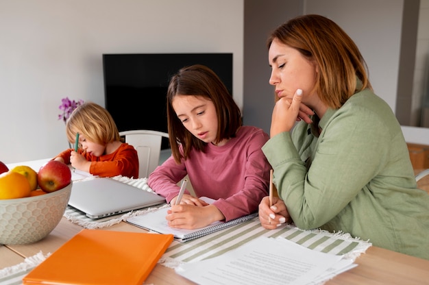 A parent helping their child with homework at a kitchen table, with documents related to taxes and education expenses visible, illustrating the family aspect of claiming the AOTC.