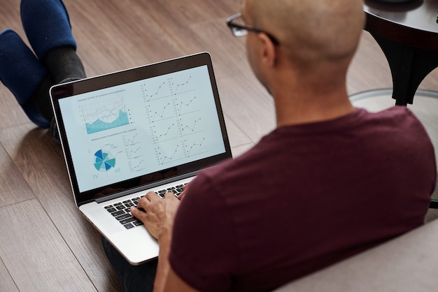 A person using a laptop with financial charts and graphs displayed on the screen, symbolizing research and analysis for international investing.