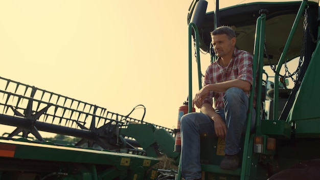 Photo of a farmer inspecting a field of crops, with a modern tractor in the background, illustrating the operational aspect of farmland and potential collaborations with agricultural professionals.