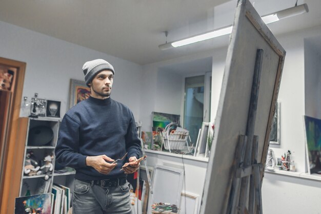 An image of an art conservator carefully restoring a painting in a studio. The conservator is using specialized tools and techniques to repair damage and preserve the artwork. The studio is well-lit and organized, reflecting the meticulous nature of art conservation.