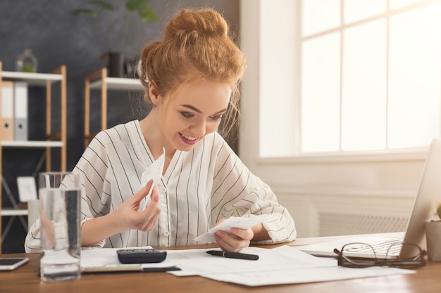 A person sitting at a desk, reviewing documents related to student loans with a calculator and a pen nearby, highlighting the process of assessing eligibility for loan forgiveness programs.