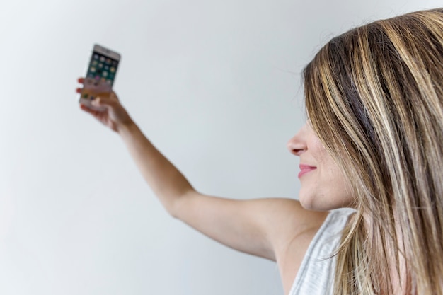 A close-up shot of an energy-efficient thermostat being adjusted. The display shows a significant reduction in energy usage compared to the previous week, with smiling icons of people using less energy on their appliances.