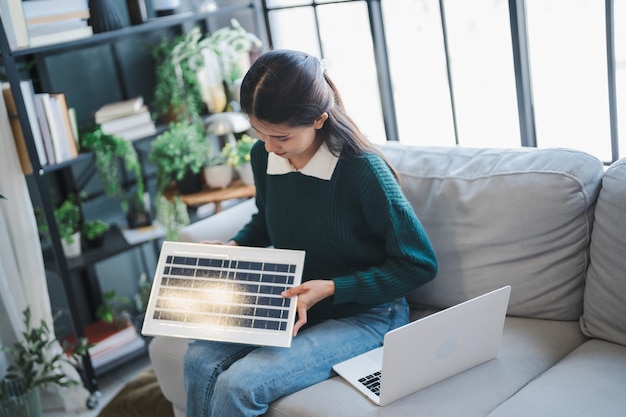 A person using a laptop to search for energy efficiency rebates online. The screen displays a website with various local energy efficiency programs and incentives listed.