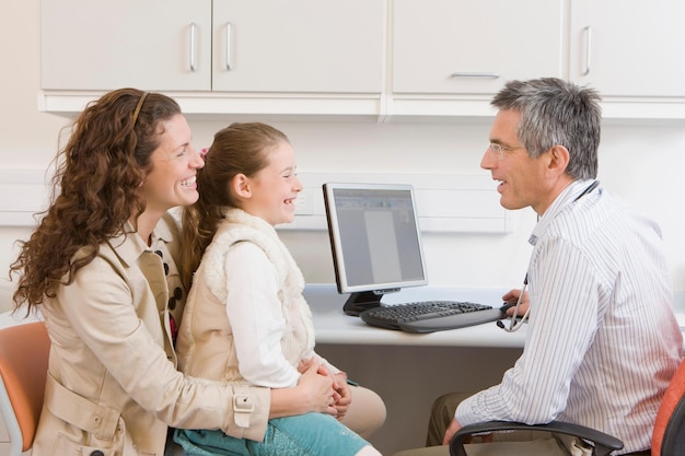 A family smiling and receiving assistance from a healthcare professional at a community clinic, representing the accessibility and support provided by Medicaid and similar programs.