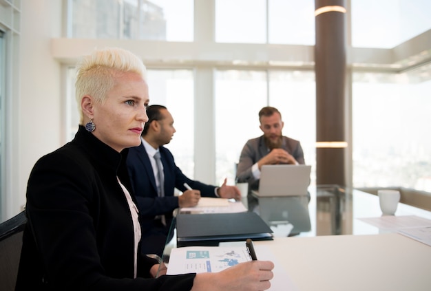 A woman entrepreneur presenting her business plan to a panel of judges in a bright, modern office setting, showcasing innovation and competence.