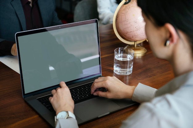 A person using a laptop to research a resource provider. The laptop screen shows search results from the Better Business Bureau and other consumer protection websites. The person is taking notes in a notebook, reflecting careful investigation.