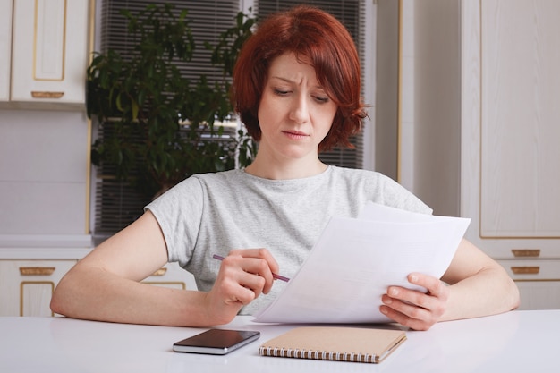 A person looking puzzled while reviewing tax forms, highlighting the importance of understanding the rules and regulations surrounding the Saver's Credit to avoid confusion and errors.