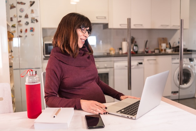 A person using a laptop at a home office, researching health insurance options and comparing plans. The scene suggests the careful consideration self-employed individuals must give to their healthcare choices and how it relates to tax deductions.
