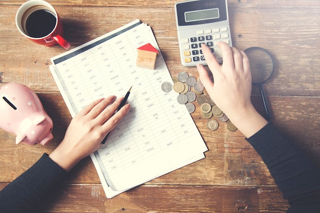 A person filling out IRS Form 1040 Schedule R with a calculator and tax preparation guide beside them. The image signifies tax calculation.