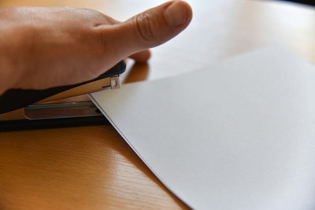 A close-up shot of a hand holding a pen, filling out a FAFSA form with a calculator and various financial documents in the background. The focus is on the meticulous process of completing the form accurately.