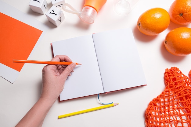 A close-up of a hand writing on a notebook with a pen, surrounded by brainstorming notes, highlighters, and a cup of coffee. The focus is on the writing process and the creativity involved in crafting a compelling essay.