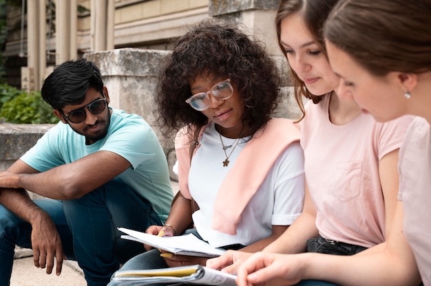 A diverse group of college students studying together on campus, with a focus on their collaborative effort and academic environment, symbolizing the benefits of receiving financial aid.