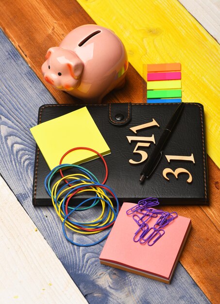 A close-up shot of a family budget planner, with highlighted sections for childcare expenses, education savings, and healthcare costs. The planner is open on a wooden desk with a pen resting on top, emphasizing the importance of financial planning for families.