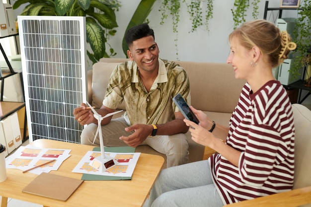 A family discussing solar panel installation options with a solar energy consultant in their living room. The image portrays professional advice and decision-making for renewable energy adoption.