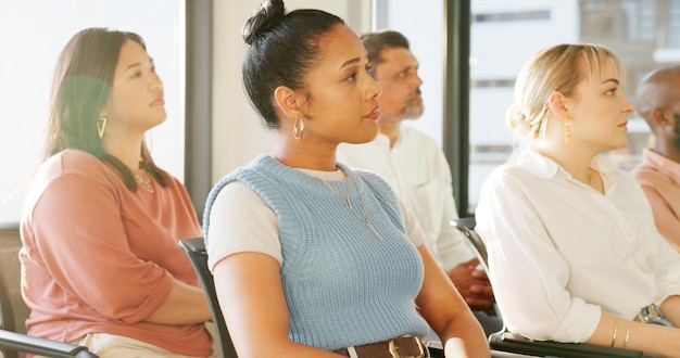 A diverse group of adults in a classroom setting, actively participating in a vocational training session, focused on learning new technical skills, with an instructor guiding them.