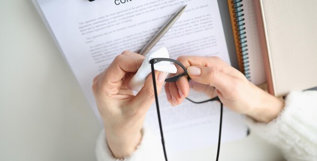 A close-up shot of a person meticulously filling out an application form with a pen, surrounded by various documents such as a driver's license, educational transcripts, and proof of income, highlighting the importance of accuracy and completeness in the application process.