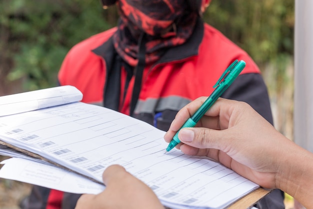 A close-up shot of a FEMA application form, highlighting sections for personal information and disaster details. A hand is filling out the form with a pen.