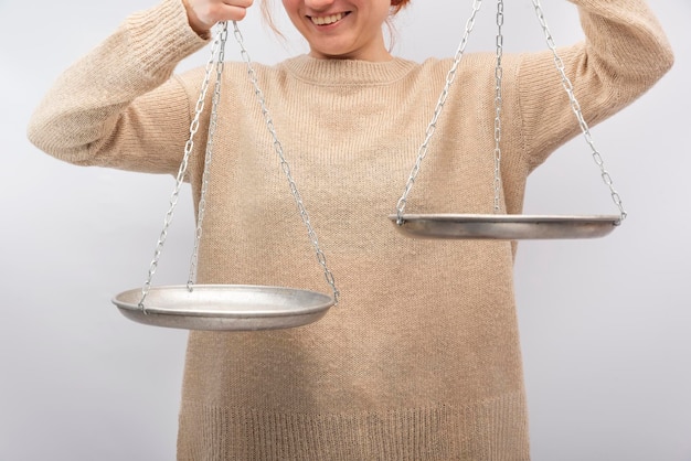 An image of the scales of justice with a helping hand reaching out, symbolizing legal support for those in need. The background is blurred to focus on the hand and scales.