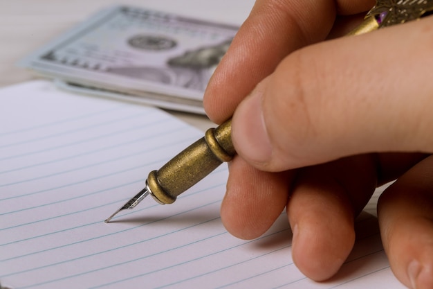 A close-up shot of a hand pointing at a specific line on a tax form, with a pen resting nearby. The image focuses on the detail and precision required when dealing with tax-related documents.