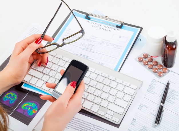 A person organizing medical bills and insurance statements in a folder, symbolizing the importance of keeping track of healthcare expenses for potential tax deductions. A calculator is nearby.