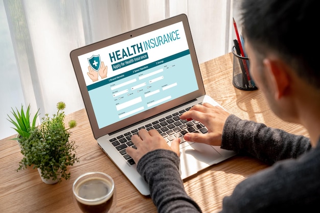 A person using a laptop to browse a health insurance marketplace website with various health plan options displayed.