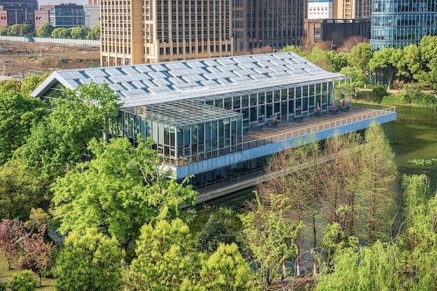 A commercial building with a green roof, solar panels, and energy-efficient windows. Highlight the comprehensive energy-saving measures.