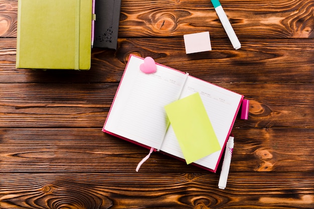 An open textbook with a highlighter marking key sentences, surrounded by sticky notes and a pen, conveying the importance of study and academic success.