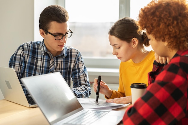 A parent and student working together at a desk, surrounded by financial documents, highlighting the team effort required to prepare for the FAFSA application.