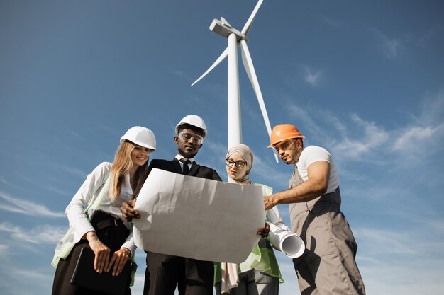 A diverse group of people working on a renewable energy project, such as installing solar panels or maintaining a wind turbine. The scene should convey collaboration and innovation.