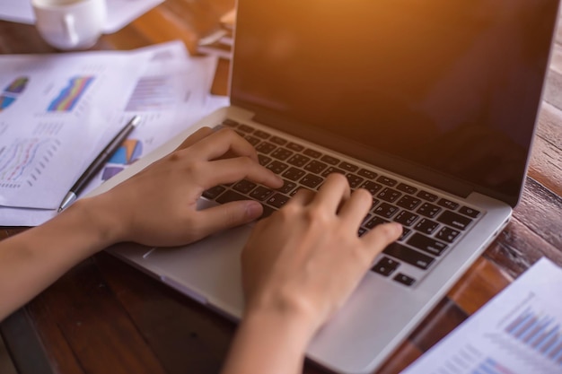 A close-up shot of a person's hands typing on a laptop, with a tax form visible on the screen. The lighting is soft and focused on the laptop, emphasizing the importance of online tax preparation.