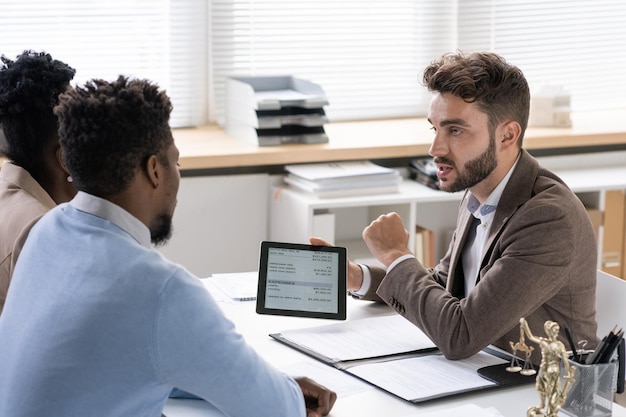 An advisor helping a job seeker to improve his resume in an office environment.